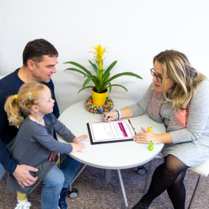 blond woman sitting at a table with a white man and his young daughter